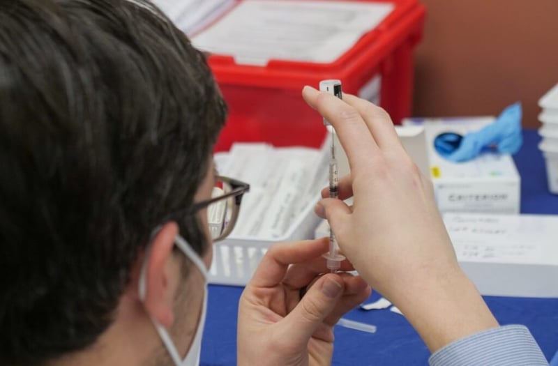 Doctor preparing needles for vaccine
